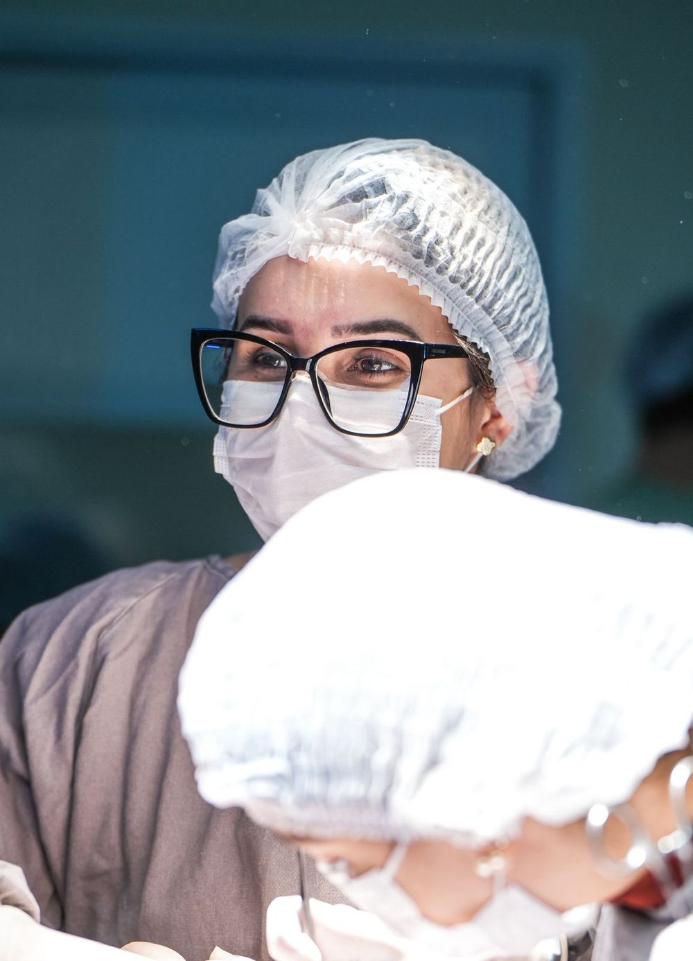 Cirurgiã sorrindo por trás da máscara no centro cirúrgico